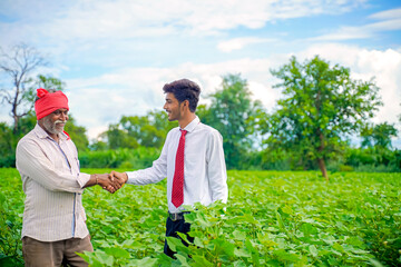 Indian farmer with agronomist at Cotton field and hand shaking