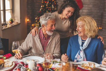Daughter hugging her parents during Christmas dinner