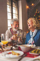Senior couple making a toast during Christmas dinner with family