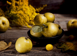 Wild, yellow apple on wooden background