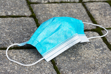 Benutzte Maske liegt auf dem Gehweg