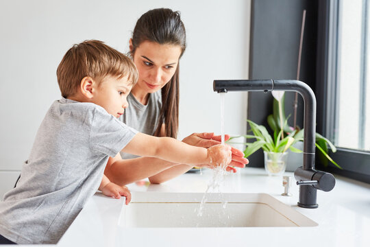 Kind lernt Händewaschen mit Seife durch Mutter