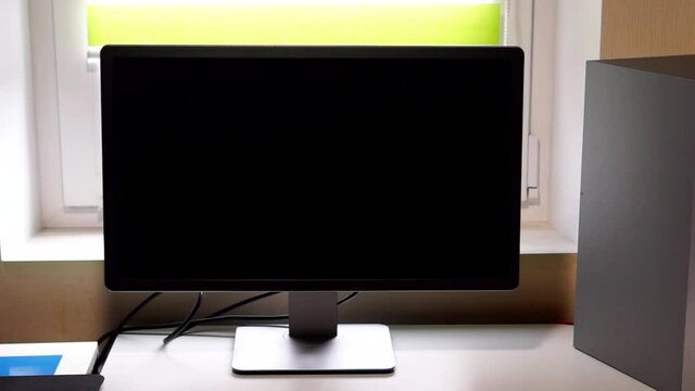 Monitor of computer with black screen by the window in room