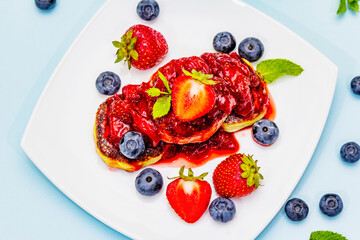Cottage cheese pancakes with fresh berries and strawberry sauce. Healthy breakfast concept for kids