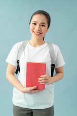 Woman with a bag and red books on her hands over blue background