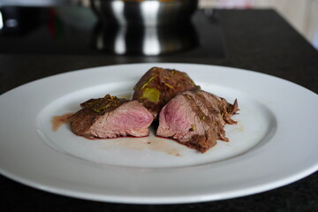 fresh cooking at home and ready to eat - roasted game meat from the red deer calf