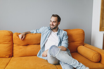 Smiling handsome attractive pleasant young bearded man 20s wearing casual white t-shirt blue shirt...