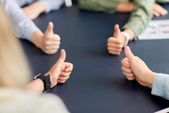 success, business and team work concept - close up of hands showing thumbs up