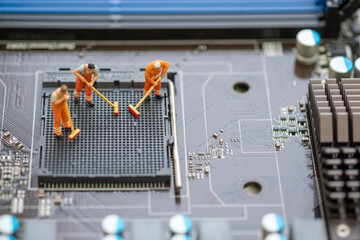 Miniature People: Worker cleaning professional repairman holding a cleaning brush inside old personal computer. CPU cleaning and maintenance concept, close up view..
