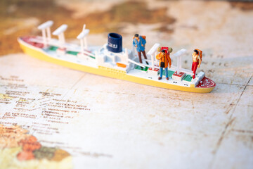 Miniature people: Group backpacker on vintage world map with boat using as business trip traveler adviser agency or explorer on earth background concept.