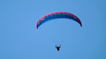 a paraglider on the clear blue sky