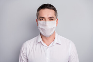 Close-up portrait of his he nice attractive healthy mature guy wearing safety mask stop pandemia influenza flu flue grippe disease sickness illness isolated light gray pastel color background