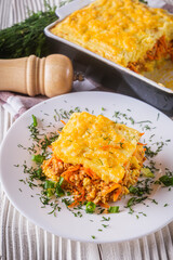 Delicious potato casserole with meat and cheese on a white wooden background