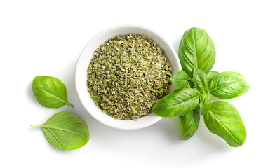 Dry marjoram in bowl and fresh basil leaves isolated on white background. Top view.