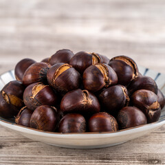 Delicious cut roasted chestnuts with oil and sugar, healthy eating snack in life, close up.