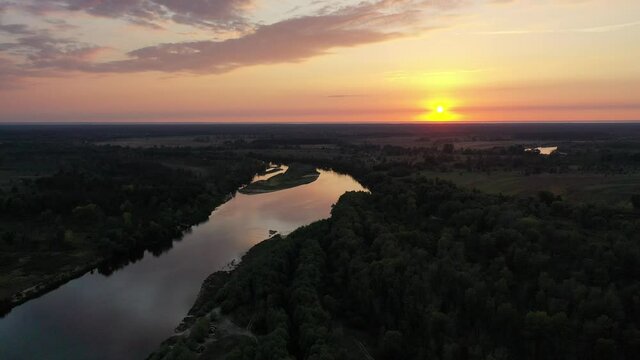 Aerial view. Beautiful sunset over the Desna river. Untouched nature by the river. River in the forest.