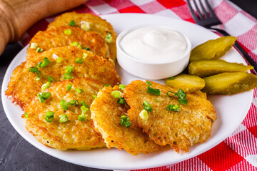 Delicious crispy potato pancakes on dark stone background