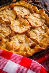 crispy apple galette with almonds on rustic wooden background