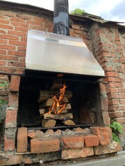 Fototapeta na wymiar Bricks campfire with burning firewood