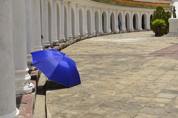 Blue umbrella on the floor near the big pagoda on a sunny day.