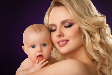 portrait of a beautiful blonde girl with skillful makeup with a baby close-up