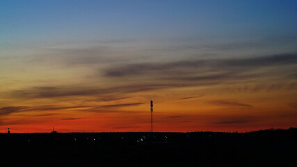 Fototapeta na wymiar A beautiful rich orange sunset and the cell tower