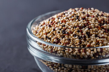 mix of quinoa grains on a dark stone background