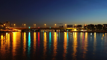 Fototapeta na wymiar Night embankment of the Moscow river. metro-bridge. reflection of multicolored lanterns in the water