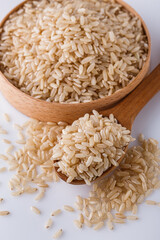 raw brown rice on white acrylic background