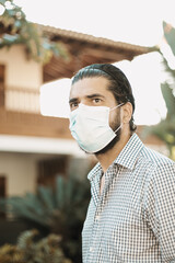 Selective focus shot of an attractive male wearing a facial mask - concept of new normal