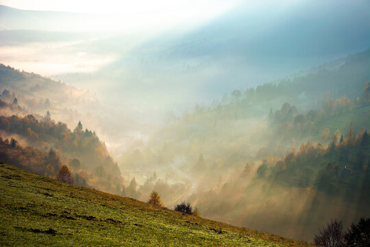 foggy mountain landscape at sunrise. beautiful autumn scenery in the valley. mist in morning light