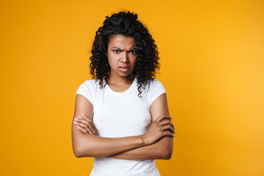 Image of irritated african american woman posing with hands crossed