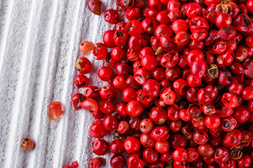 pink peppercorns on white wooden rustic background