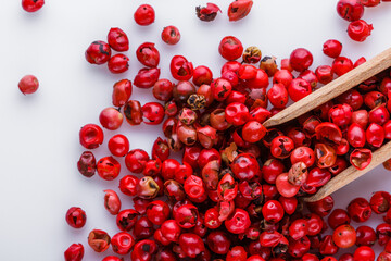 fragrant pink peppercorns on white acrylic background