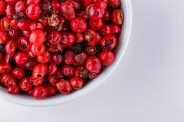 fragrant pink peppercorns on white acrylic background