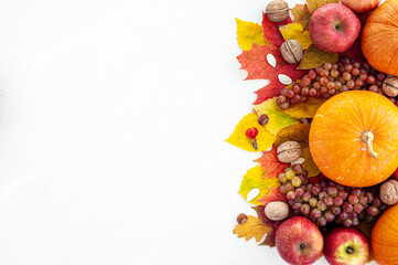 Naklejka na ściany i meble Harvest. Thanksgiving. The composition of autumn fruits, vegetables, nuts and leaves on a light background. View from above. A place for text.