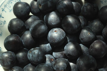 plum berries on a plate in the sun
