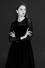 Portrait of a young woman in a black dress on a dark background