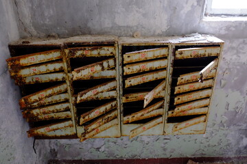 An old broken mailbox in an apartment building.