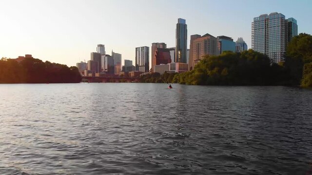 Kayaker paddling towards Downtown Austin Texas. Straight shot that follows the Kayaker. August 2020