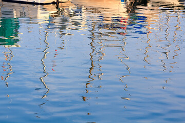 reflections in the mast of sailboats