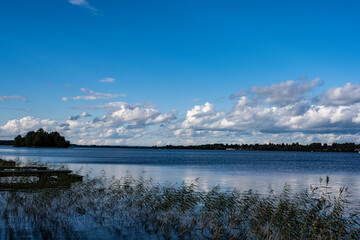 view of a large beautiful lake against the backdrop of clouds and blue sky