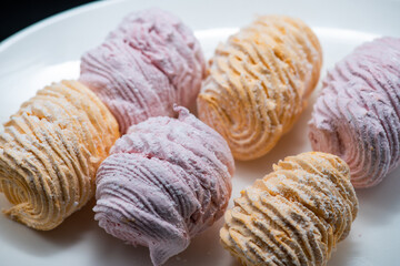 Delicious marshmallows on a plate on a dark background