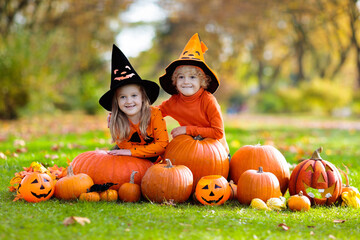 Kids with pumpkins in Halloween costumes