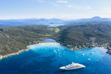 Naklejka premium View from above, stunning aerial view of the Grande Pevero beach with boats and luxury yachts sailing on a turquoise, clear water. Sardinia, Italy.