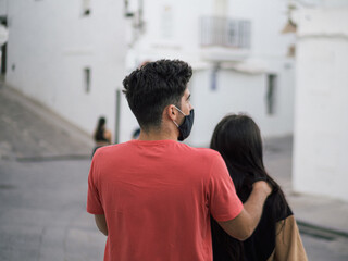 Beautiful young couple wearing medical masks on a romantic date - the new normal due to Covid-19