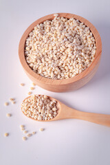 Barley rice in a wooden cup on a white background