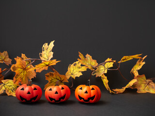 Halloween Party. Three Jack pumpkins on a background of autumn leaves.