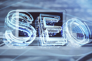 Multi exposure of table with computer and seo drawing hologram. Search optimization concept.