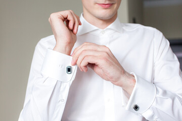 a man in a white shirt adjusts his bow tie